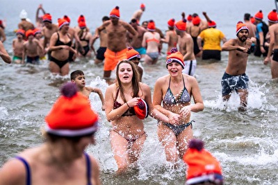 Deelnemers rennen de zee in tijdens de Nieuwjaarsduik Rockanje bij de 1e Slag.